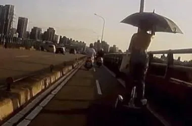移動神主牌！露背辣妹撐大傘「踩平衡車」攻福和橋　騎士嚇歪