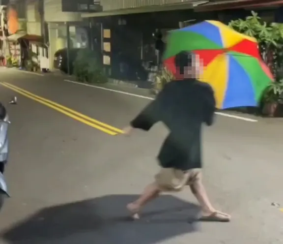 太失禮了！喝茫男撐大花傘街頭亂舞　頭身竟塞入「滾筒洗衣機」