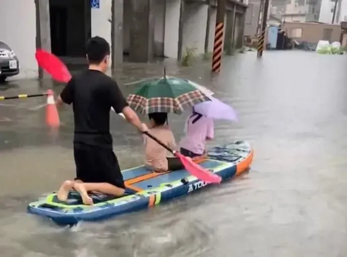 影/父親背影有淚！台南雨炸大淹水　一家三口划SUP脫困